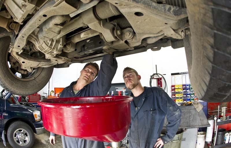 OIL CHANGE – Mechanics Chris Letwin (left) and Mark Tribble from St. Albert Tune Up &amp; Brake perform an oil change to prepare a vehicle for the cold winter ahead.