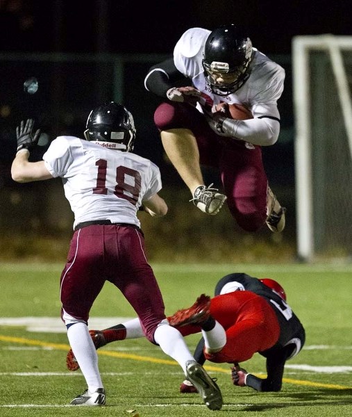 LEAP OF FAITH &#8211; Jackson Ryan of the Bellerose Bulldogs hurdles over a Jasper Place Rebel as teammate Dylan Shorten watches the play in Tuesday&#8217;s playoff game at