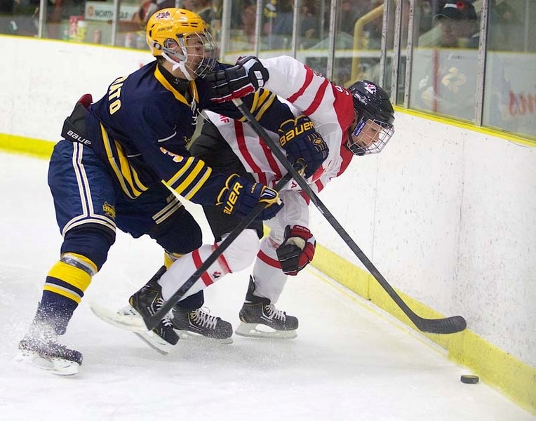 BOARD WORK &#8211; Luigi Naccarato of the midget AAA St. Albert Raiders out-muscles Team Canada&#8217;s Rebecca Johnston along the boards Monday at Northstar Hyundai Arena.