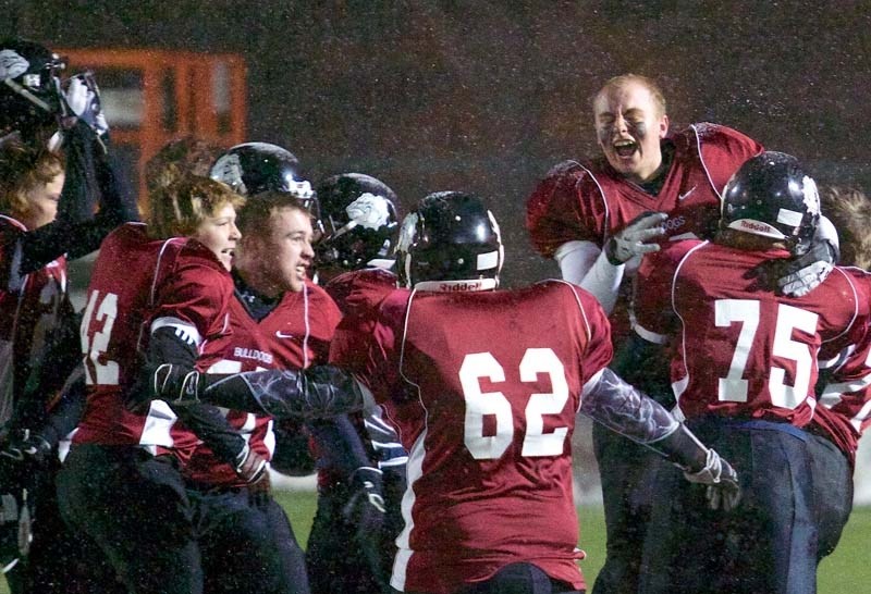HAPPY DAWGS &#8211; Tyler Fletcher hugs teammate Alex Hanna (75) as the Bellerose Bulldogs celebrate their 21-17 victory over the Jasper Place Rebels in Thursday&#8217;s