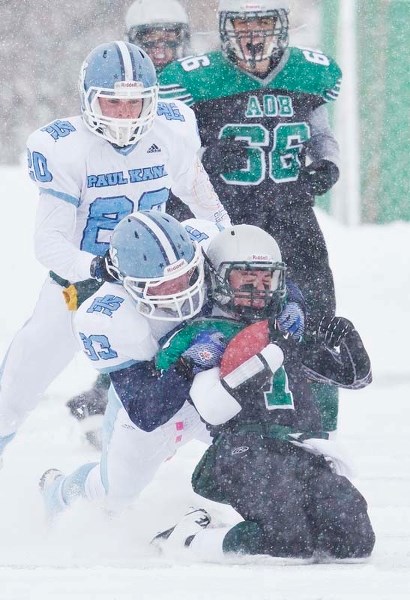 SNOW BALL &#8211; Greg Fleming of the Paul Kane Blues tackles Austin O&#8217;Brien Crusaders&#8217; quarterback Ryan Foster