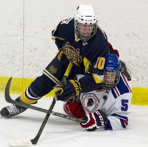 TAKEDOWN &#8211; Thomas Friesen of the St. Albert Raiders pins Brenden Montgomery of the Calgary Buffaloes to the ice during first-period action in Sunday&#8217;s midget AAA