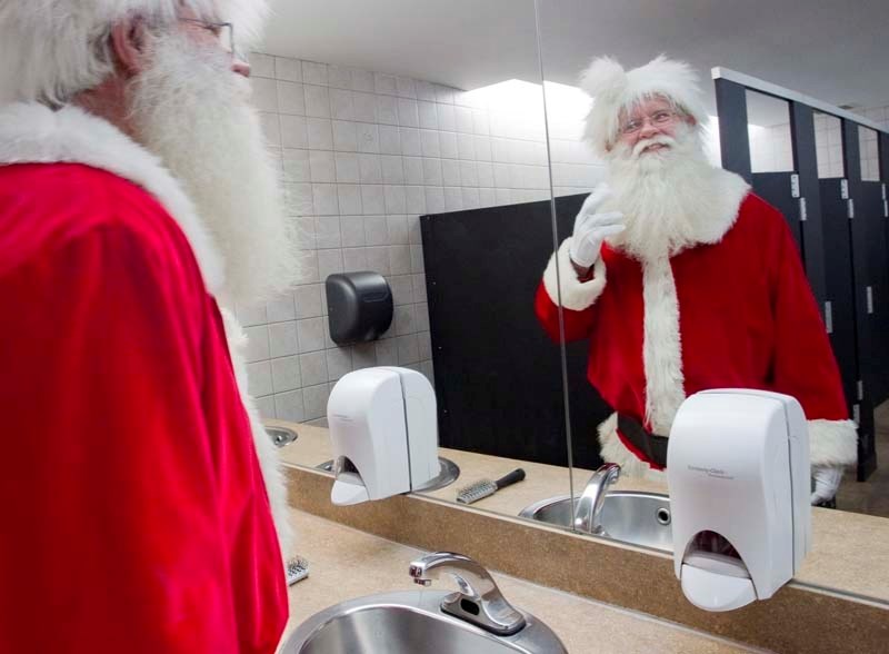 SLICK SANTA – Steve Schuster primps his beard in preparation for his first shift as Santa Claus at St. Albert Centre. Schuster is a veteran mall Santa and will be on duty at