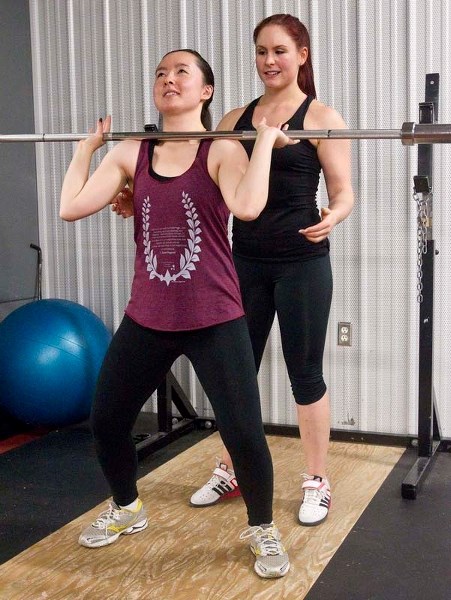 POWER LIFTING – Gazette reporter Amy Crofts works on her power clean technique under the watchful eye of trainer Megan Lauer at Servus Credit Union Place.
