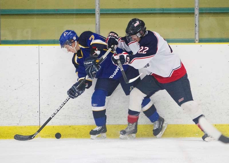 BOARD WORK &#8211; Josh Jewell of the St. Albert Merchants battles for possession along the wall against Trevor Schulte of the Stony Plain Flyers in Sunday&#8217;s junior B