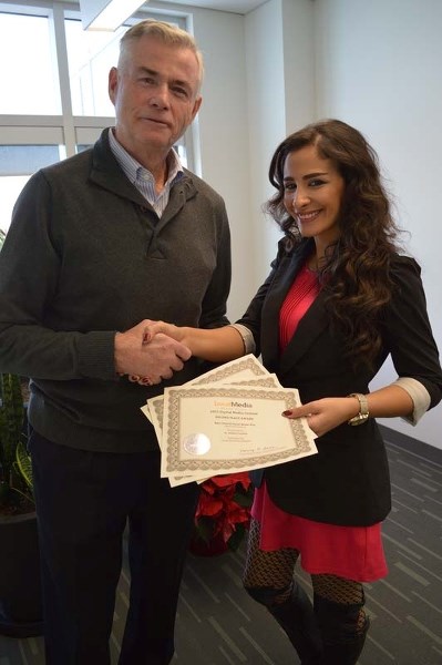 GOOD JOB – Great West Newspapers CEO Duff Jamison congratulates multimedia creative strategist Dana Kanso for some recent awards earned by the St. Albert Gazette website.