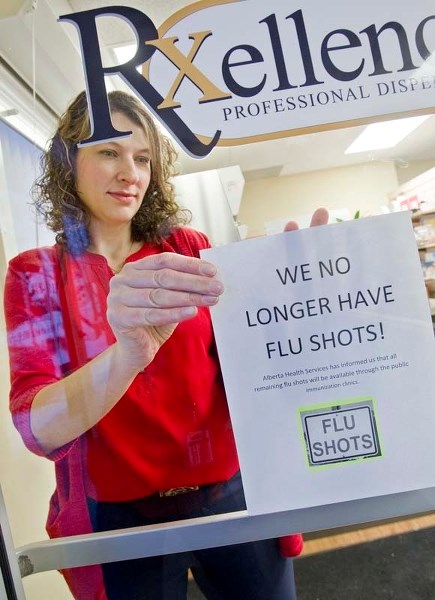 ALL OUT – Pharmacist Lisa DeVos hangs a sign informing patients that Salvus Rxellence Pharmacy on Liberton Drive no longer has any flu shots available. Patients are advised