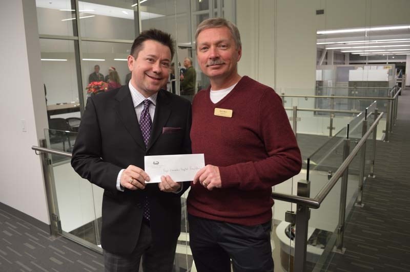 HOSPITAL HELP – Terry Tobin accepts the Dec. 18 donation from Dan Roy.