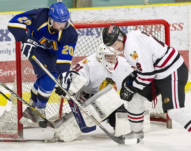 MUCKING IT UP &#8211; Taylor Wiebe of the St. Albert Merchants creates havoc in the crease against netminder Keaton Bakstad and Jeff Brown of the Beverly Warriors in game