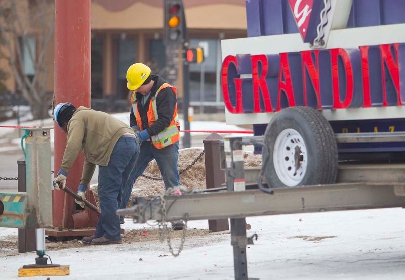 MALL CHANGES – Workers dismantle the large sign in the parking lot of Grandin Park Plaza recently. Mall tenants recently received notice that they have 60 days to move out.