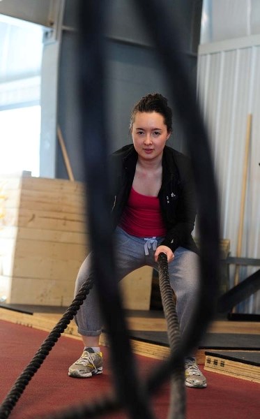LEARNING THE ROPES – Gazette reporter Amy Crofts tries her hand at a heavy rope workout at Servus Credit Union Place on Tuesday.