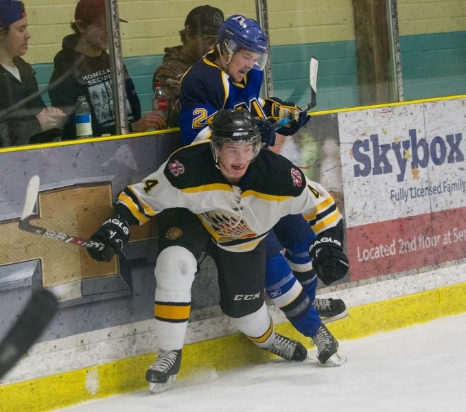 STUCK &#8211; Casey Reid of the St. Albert Merchants is pinned against the boards by Andrew Smith of the Beaumont Chiefs in game one in the best-of-seven junior B semifinal