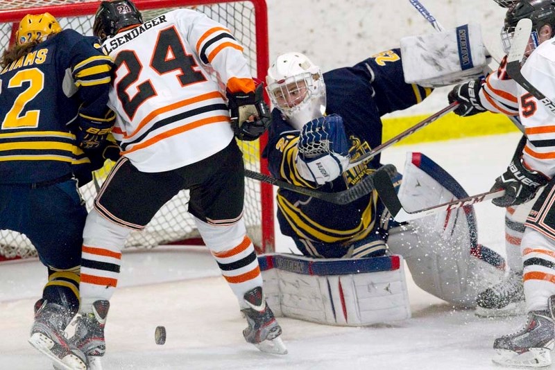 PUCK SCRAMBLE &#8211; St. Albert Raiders netminder Pat Dea searches for the puck as teammate Wyatt Williams battles Jason Hilsendager of the Lloydminster Bobcats in the