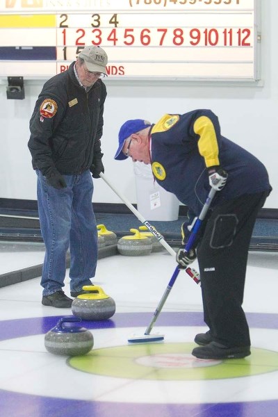 ROCKING THE HOUSE &#8211; Mel Cartier (left) of Brooks watches Jim Pyper of Winnipeg sweep a stone at the 10th annual Canadian Open Stick Curling Championship on Monday