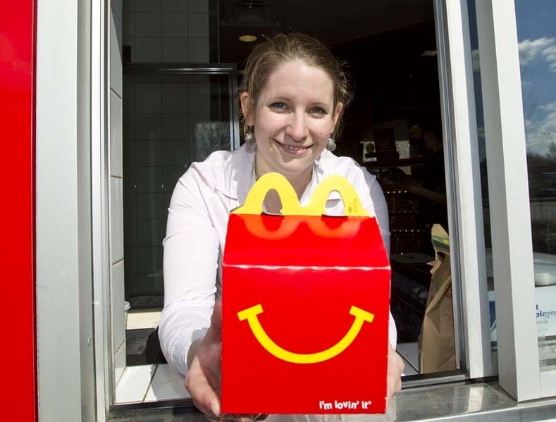 COME AGAIN – St. Albert Gazette reporter Viola Pruss hands over a Happy Meal during a volunteer shift at McDonald&#8217;s during its McHappy Day on Wednesday.