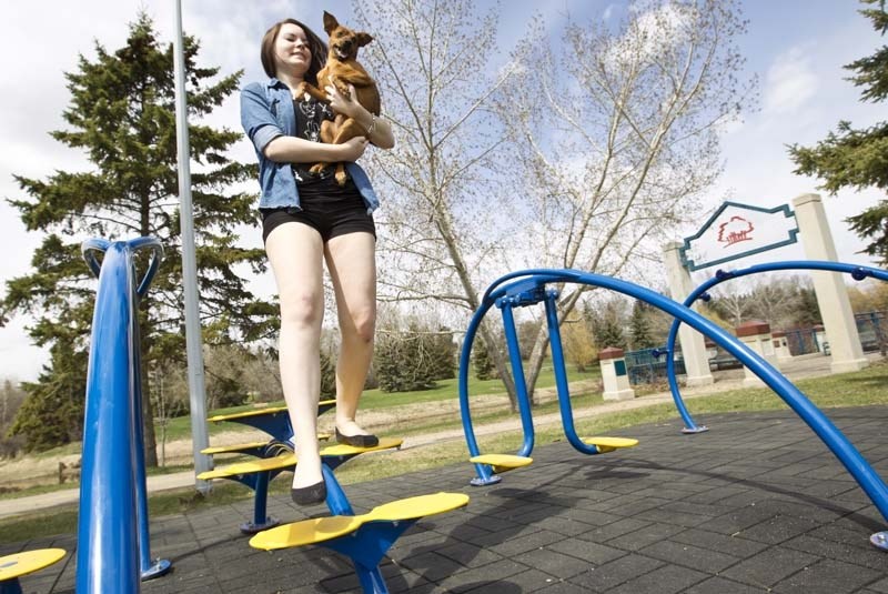 OUTDOOR EFFORT – Kassie Groom has some fun with her dog on the new outdoor gym equipment that&#8217;s been installed at Lions Park.