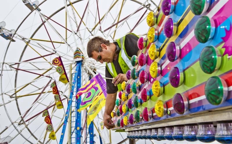 SETTING UP –Carnival worker Dallas Smith sets up the Sizzler ride at the Kinsmen rodeo grounds on Thursday afternoon. Smith says he&#8217;s worked with West Coast Amusements