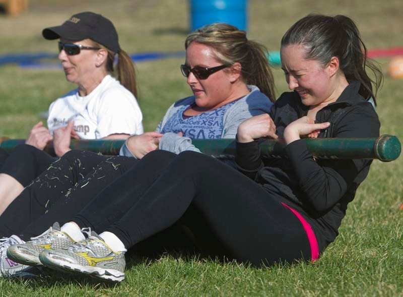 BAR WORK – Gazette reporter Amy Crofts (right) and her exercise partners struggle with a 40-pound plumber&#8217;s pipe during a session at Back Yard Boot Camp at Fowler Track.