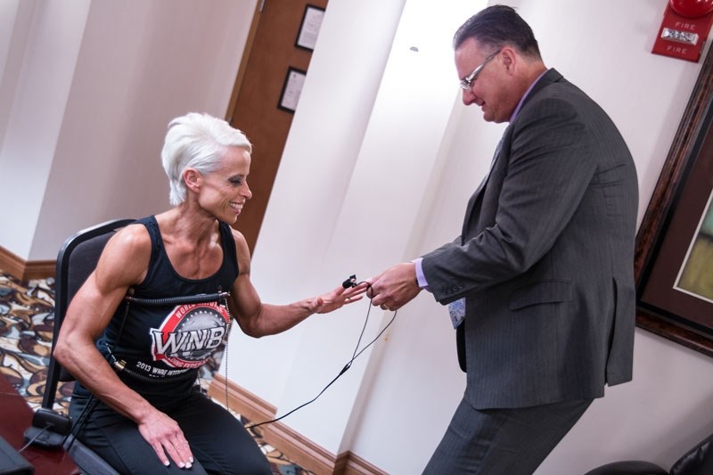 THE WEIGHT OF THE TRUTH – ITR Polygraph Service co-owner Ken Donaldson applies various sensors to athlete RoAnna McLenahan in preparation for a polygraph exam last month at a 