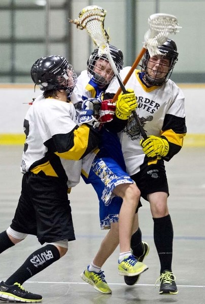 CRUNCHED &#8211; Andrew Neufeld of the midget B St. Albert Rams is sandwiched by a pair of Lloydminster Brutes at the Jeremy Richardson Memorial Baggataway Tournament on
