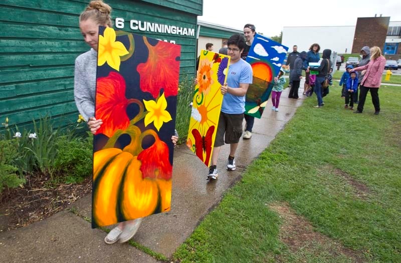 STUDENTS CARE – Art students from Paul Kane High School carry some of the many painted pieces of a large mural that will be hung at the neighbouring St. Albert Day Care