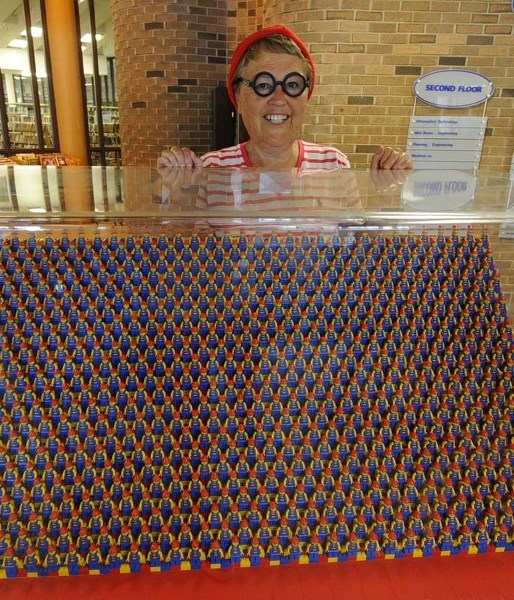 LOOKING FOR WALDO – Barb Moreau dressed as Waldo poses in front of the Where&#8217;s Waldo Lego exhibit at the St. Albert Library.
