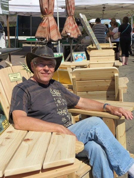 KICKING BACK – Wayne Hryniw of Wayne&#8217;s Cedarworks relaxes on some of the handcrafted outdoor furniture that has kept him in business at the St. Albert Farmers&#8217;