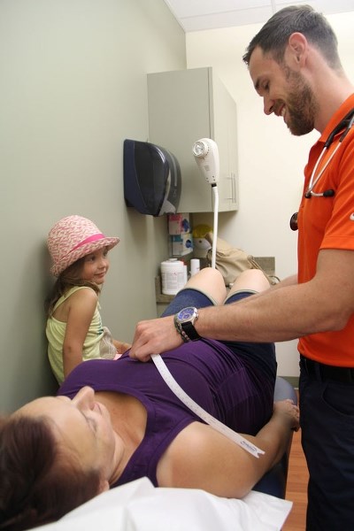 MORE BABIES &#8211; Medical resident Dr. Jeff Jamieson measures April Baldonado during her 21-week check-up at the St. Albert maternity clinic. The clinic took over new space 