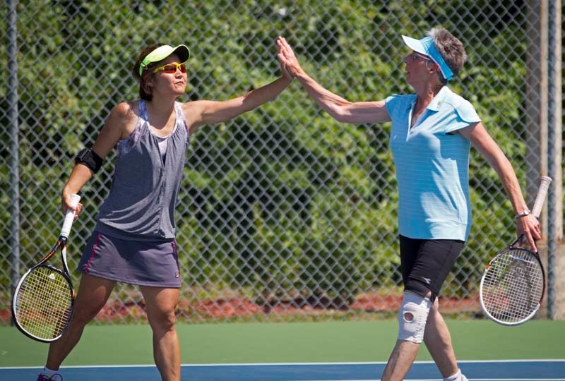 BACK AND FORTH – St. Albert tennis partners Mayumi Hagiwara (L) and Margo Jerace (R) high-five during a provincial finals doubles match at the St. Albert Tennis Club