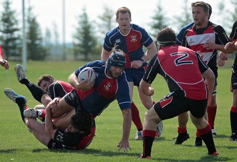 LEG TWISTER &#8211; Isaac Foley of the St. Albert premier men&#8217;s team hangs onto the ball while tackled in Saturday&#8217;s 29-24 victory over the Calgary Saints. The