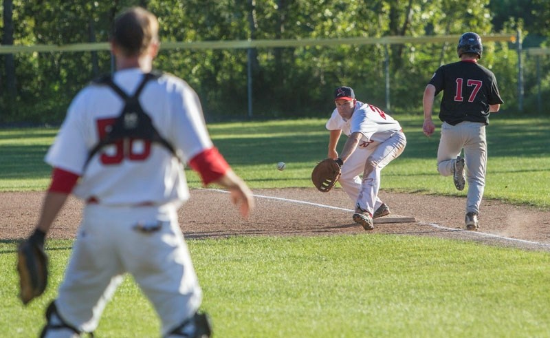 STRETCH PLAY &#8211; Darren Milne reaches for the ball at first base as catcher Paul Radchenko watches the play unfold for the St. Albert Senior Cardinals against the