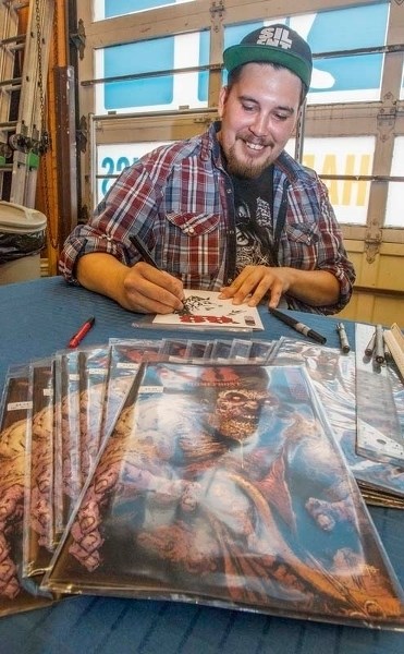 BIG STAR – Edmonton artist Kyle Charles inks a custom cover for a fan at Happy Harbor in Edmonton. He is one of a handful of local artists who draw or write comics for a