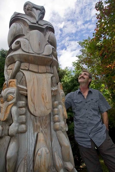 – Norm Belley of St. Albert with his totem pole at his home recently. Belley spent 10 years carving the piece he calls a Family Unity Pole. It was installed in his front yard 