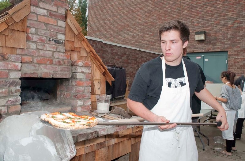 HOT STUFF – Bellerose student Sean Malayko pulls a piping hot margherita pizza from his school&#8217;s new wood-fired oven Wednesday. The food was part of a pizza sale put on 