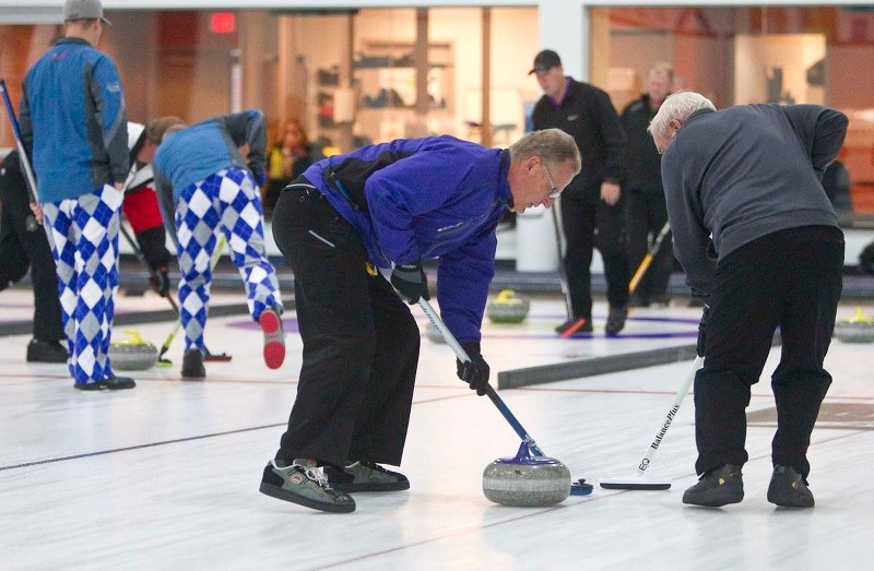 BACK ON THE ICE &#8211; Al Schultz (left) and Dave Elaschuk pull the rock towards the house for the Brad Haggith rink Tuesday night at the St. Albert Curling Club. The