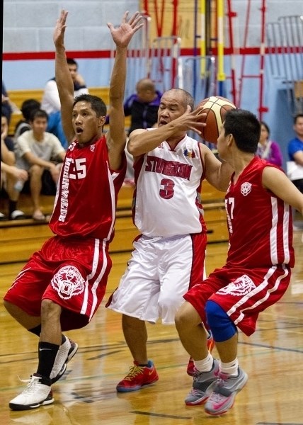 HOOPING IT UP – Jun Celso of the Sturgeon Raptors (Sturgeon Community Hospital) controls the ball against Jerry Labio (left) and Laude Evora of the Morinville Tigers in the