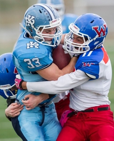 ENGULFED &#8211; Brandon Smith of the Paul Kane Blues is wrapped up by the W.P. Wagner Warriors in the last Miles division two game before the playoffs in the metro Edmonton