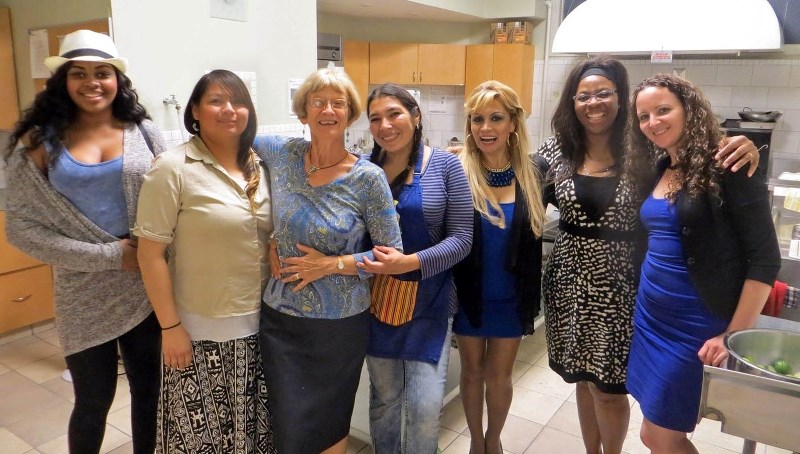 Members of the Standing Up for Peruvian Children board are joined by a singer and the evening&#8217;s cook in the kitchen at this year&#8217;s Peruvian dinner fundraiser.