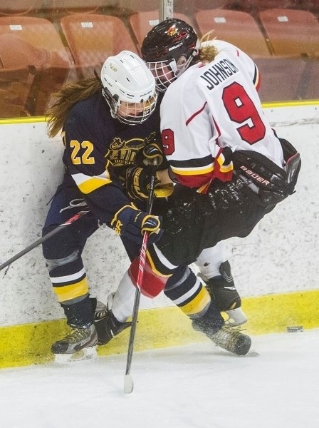 BOARD WORK – Brooke Tipton of the St. Albert Slash and Isabel Johnson of the Calgary Fire collide along the boards while battling for the puck in Saturday&#8217;s game at Go