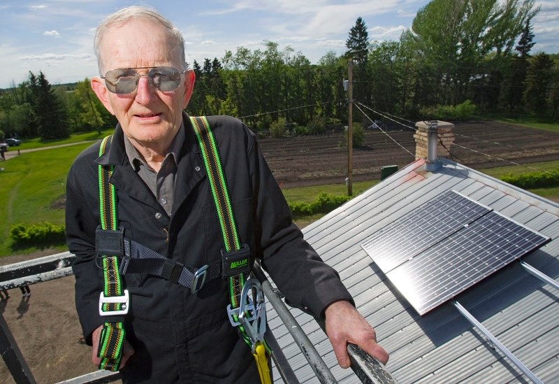 John Bocock oversees the installation of photovoltaic (solar) panels on the roof of his dairy barn in 2010. He is just one of many people making use of solar energy to save