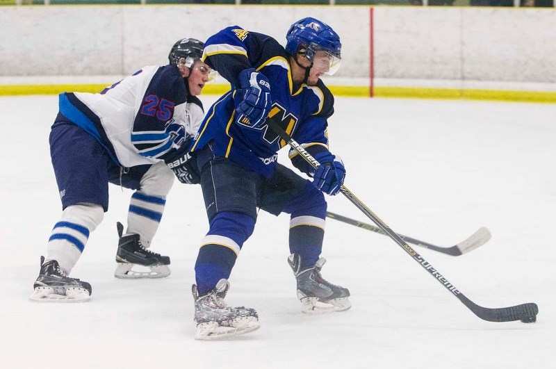 CHECKING THE ATTACKER – Jed Groenenboom of the St. Albert Merchants is pressured by Brett Kampjes of the Morinville Jets in a recent Capital Junior B Hockey League game at