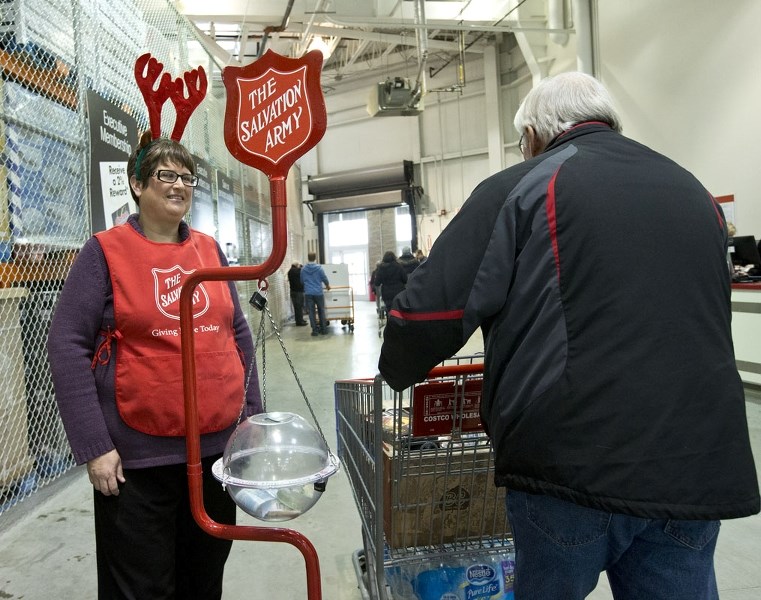 Kim Opalinsky wears her lucky antlers and a smile to encourage Costco shoppers to donate to the Salvation Army&#8217;s Christmas kettles on Friday.