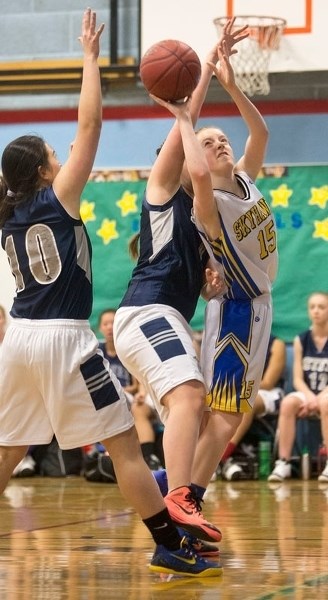 EXTRA EFFORT – Michaela Pacholok of the St. Albert Skyhawks battles for a basket while pressured by the St. Francis Xavier Rams at the Gologo Invitational high school junior