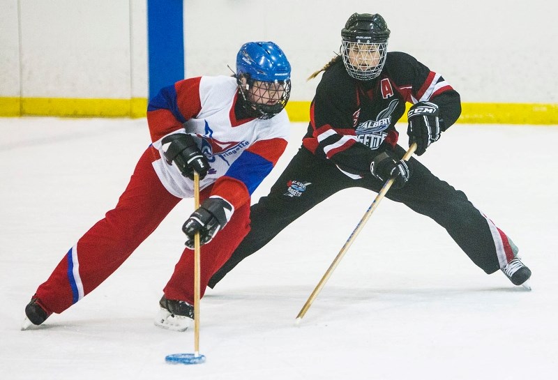 CHECKING IN &#8211; Taylor Ostafichuk of the St. Albert Mission U16 AA juniors zeros in defensively on the Calgary Hype ring bearer at the Wood tournament last month. The U14