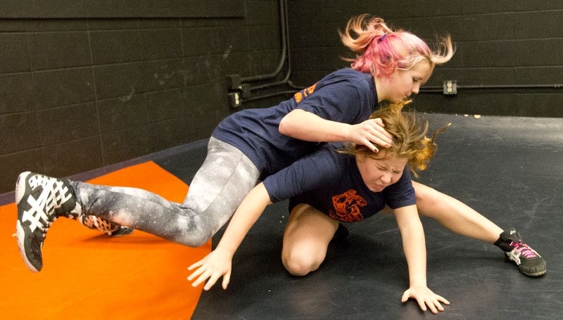 CRUSHING THE MAT – Parker Seymour makes a move on Alexa Bereziuk at the Lorne Akins Crush practice Monday. The junior high wrestling team produced 12 top-three results at its 