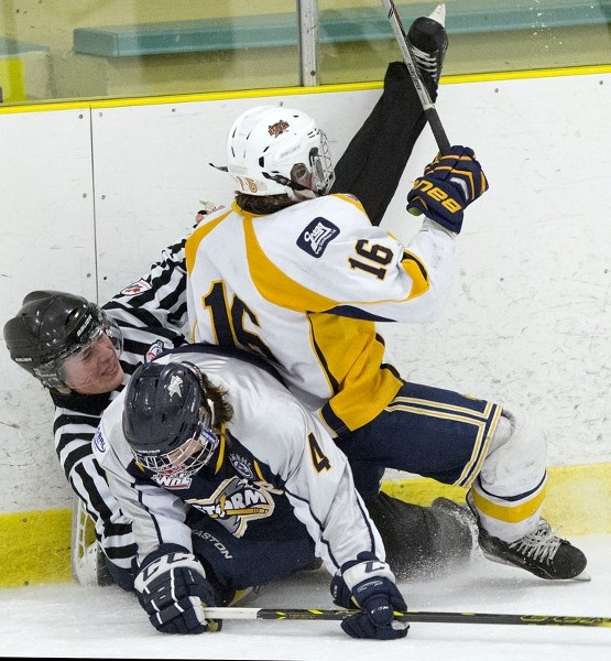 BOARDING – Linesman Erik Sabrowski is pinned against the boards by Zach Giacobbo (16) of the St. Albert Sabres and Austin Schellenberg of the Grande Prairie Storm during a