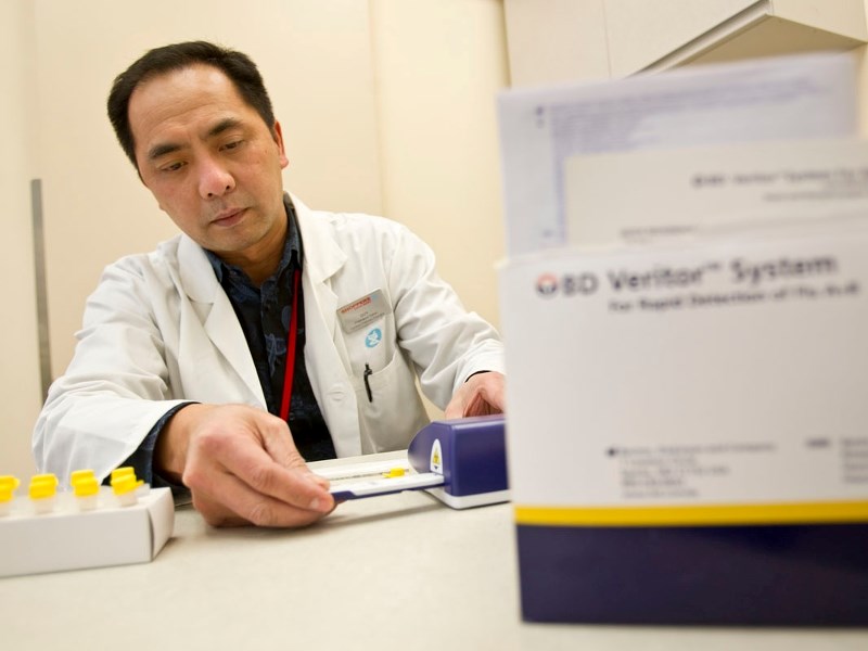 RAPID DIAGNOSIS &#8211; Pharmacist Duy Truong operates the new rapid influenza diagnostic tests now being offered at Shoppers Drug Mart pharmacies to adults with flu symptoms.