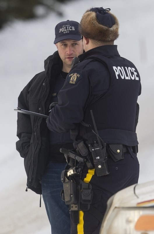 Police talk at scene at a residence in Sturgeon Heights Saturday afternoon investigating the area where the suspect in the shooting of two St. Albert RCMP members was found