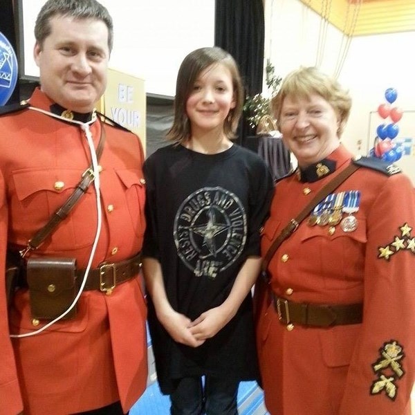 Cst. David Matthew Wynn and Cpl. Laurel Kading pose with a DARE program grad. Wynn is one of the 10 officers who teaches the Drug Abuse Resistance Education (DARE) program in 
