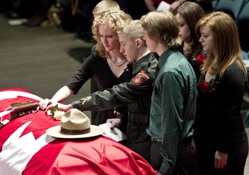 Sons Matthew (left) and Nathan Wynn attend to their father&#8217;s casket on Monday at the funeral service.